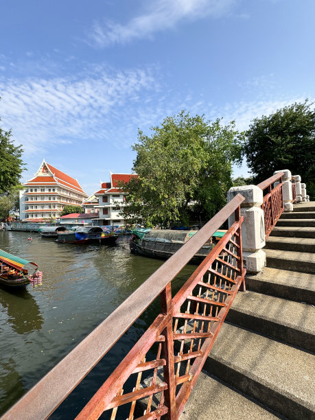 从装饰华丽的阶梯桥上俯瞰的图片，上面有带顶篷的木制游船载着游客游览Khlong Damnoen Saduak运河附近，游船行驶在通往Tha Chin和Mae Klong河的水路上图片下载