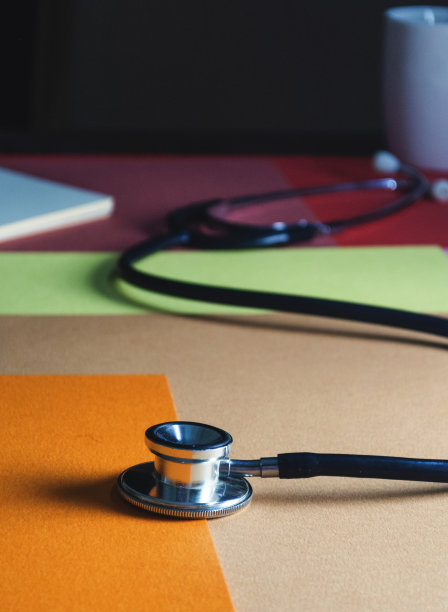 彩色背景上的黑色听诊器特写图片下载