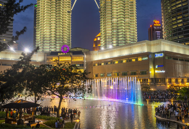 许多游客聚集在双子塔下，观看湖中交响乐表演。图片下载