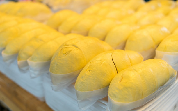 金黄色的榴莲放在塑料托盘上，整个榴莲为背景。图片下载