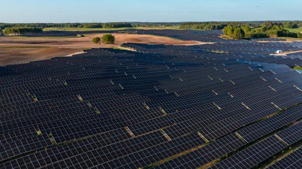 太阳能电池板上的航拍照片，阳光明媚的农村地区有绿色的土地图片下载