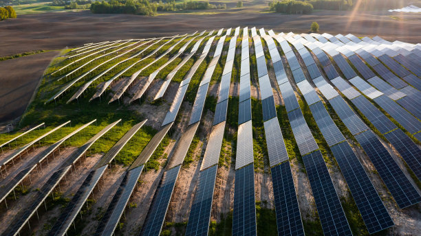 太阳能电池板上的航拍照片，阳光明媚的农村地区有绿色的土地图片下载