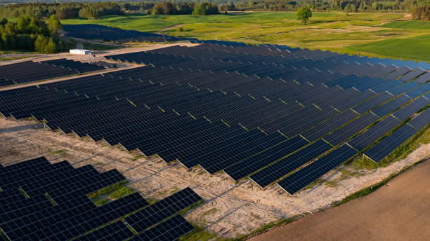 太阳能电池板上的航拍照片，阳光明媚的农村地区有绿色的土地图片下载