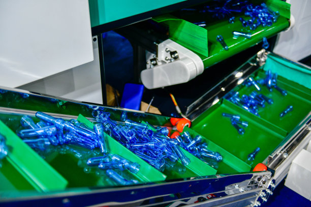 蓝色塑料瓶在生产PET的生产线上执行，在吹瓶机吹瓶前在喝水图片下载