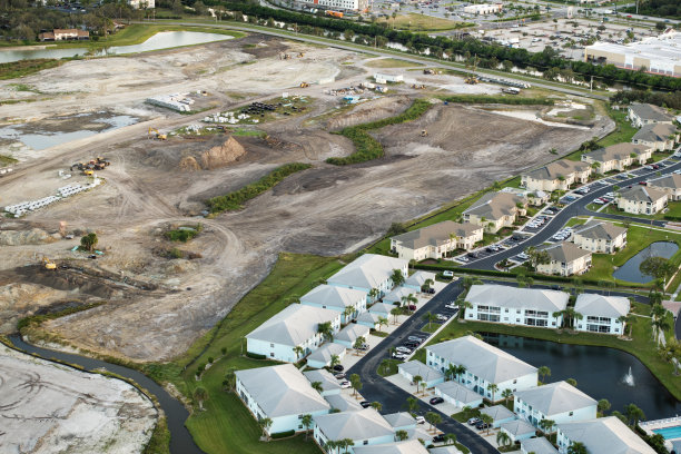 美国房地产市场的发展。美国农村准备好的土壤上大型建筑工地的建筑设备鸟瞰图图片下载