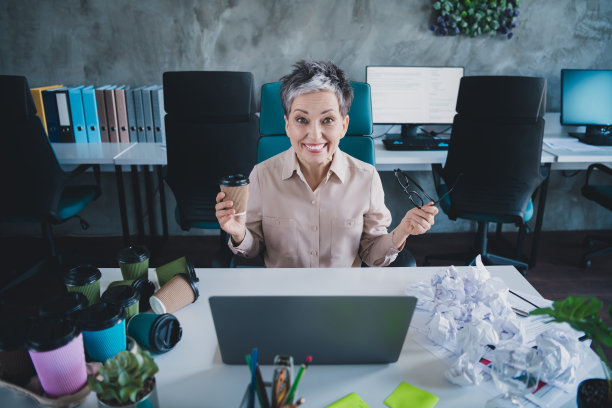 快乐迷人的高级女秘书的照片穿正装衬衫喝饮料工作现代化设备室内车间工作站阁楼图片下载