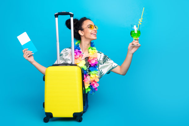 漂亮的年轻女孩的全尺寸照片手提箱鸡尾酒护照穿衬衫孤立的蓝色背景图片下载