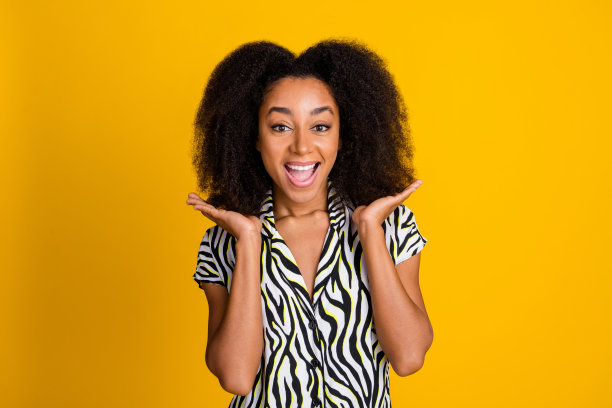 迷人的年轻迷人的女人的肖像照片显示她的雪佛兰波浪的头发在斑马印花衬衫孤立的黄色背景图片下载