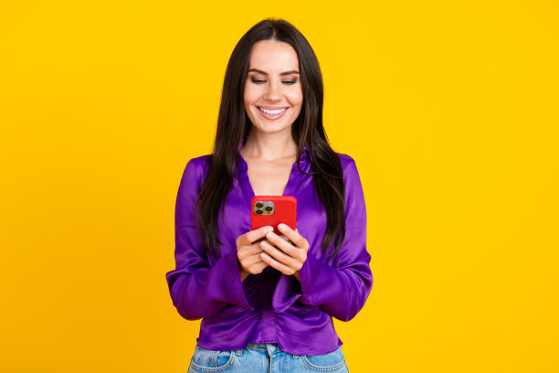 照片正面微笑的女士使用手机智能小工具隔离明亮的颜色背景图片下载