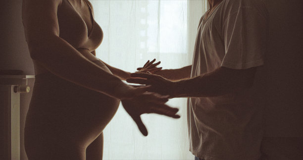 一个孕妇和一个男人争吵的剪影…女人和男人的手特写。图片下载