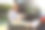 年轻女子坐在汽车后备箱里使用笔记本电脑。图片下载