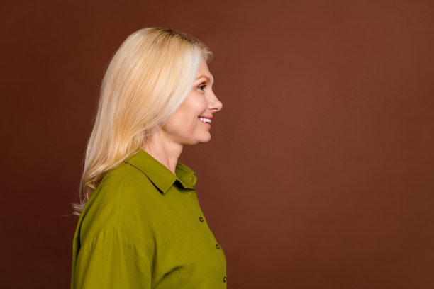 侧面资料照片的好心情可爱的女人与时尚的发型看宣传空白空间孤立的深棕色背景图片下载