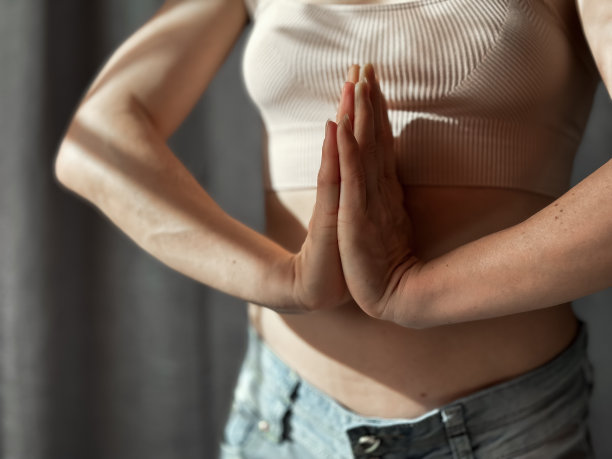 女性练习瑜伽的特写，双手处于祈祷姿势。在冥想的姿势中，专注于手臂和躯干。正念，冥想和在家健康的概念。生活照片。图片下载