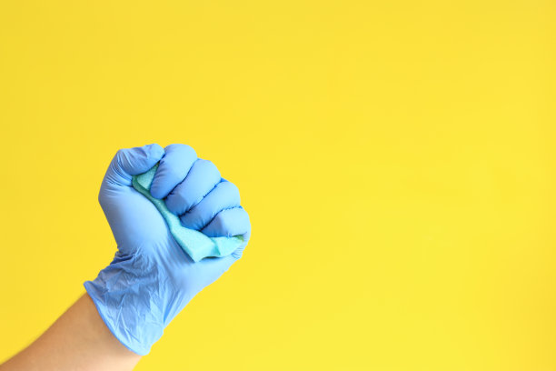 男人的手戴着带海绵的乳胶手套图片下载