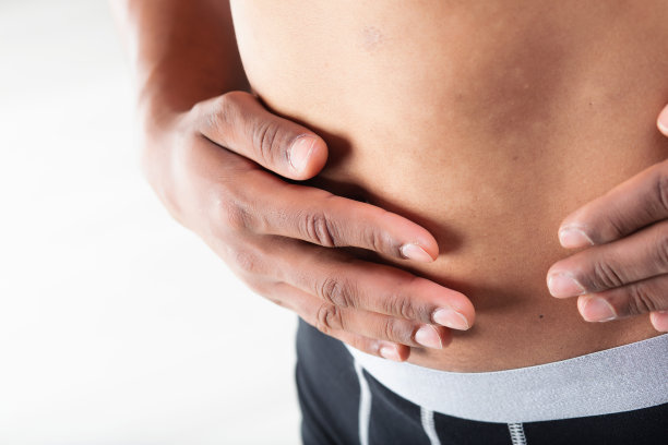 男子捂着腹部，可能有胃痛图片下载