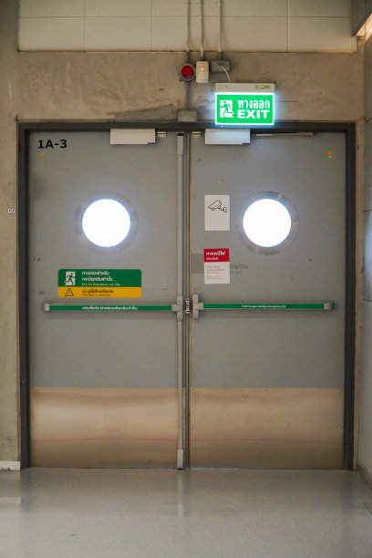 大楼紧急出口，有出口标志和灭火器。图片下载