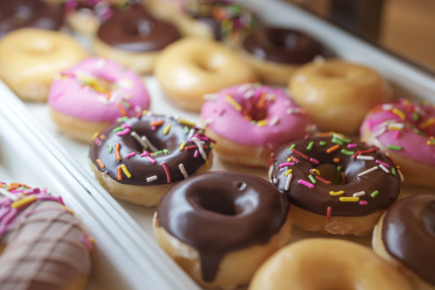 面包店货架上出售的甜甜甜圈特写。图片下载