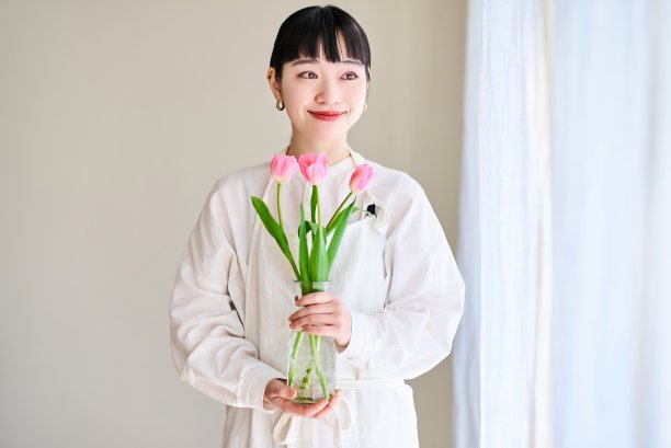 拿着一瓶花的年轻女子图片下载