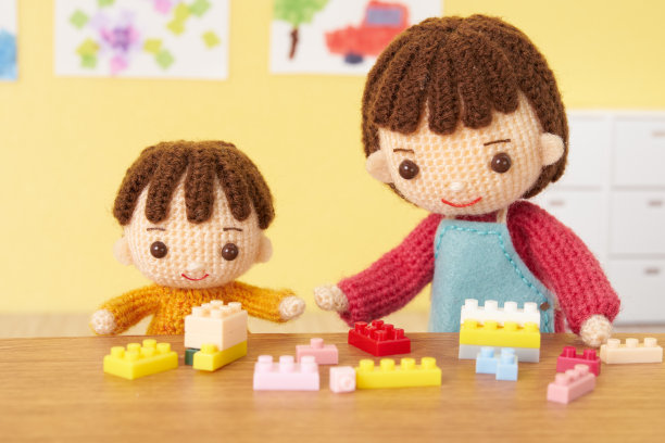 小而可爱的Amigurumi娃娃在白色的背景。照顾孩子图片下载