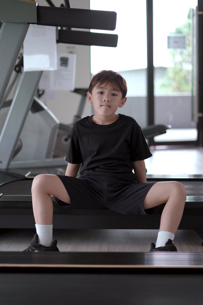 小男孩坐在跑步机上图片下载