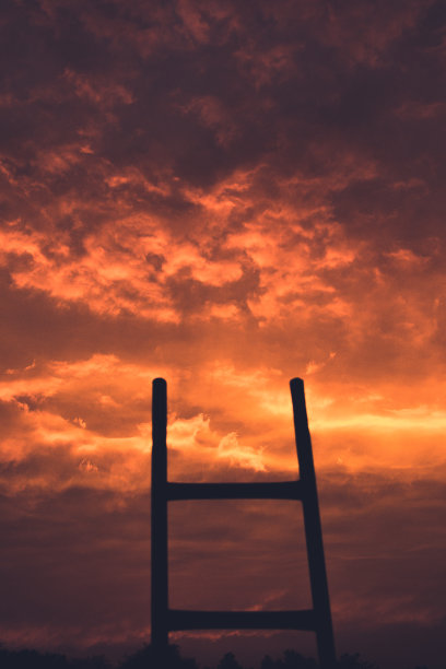 在日落时通往美丽的橙色云的楼梯-通往天堂的楼梯-概念图片下载