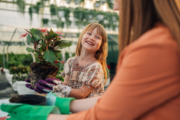 小植物学家在温室里帮助母亲园艺的照片图片下载