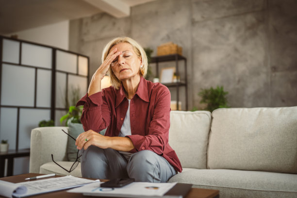 成熟的年长的女性在家工作，头疼图片下载