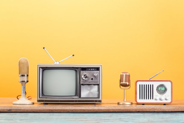 旧电视，调频收音机，金色麦克风前黄背景。复古滤镜照片图片下载