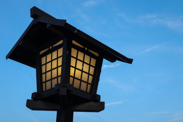 日本京都典型的装饰灯，背景是明亮的蓝天和橙色的灯光图片下载