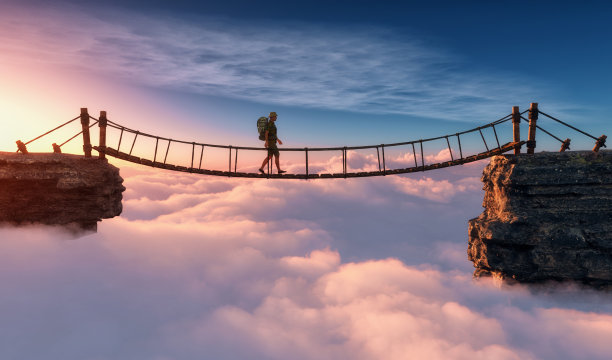 一个人走在吊桥上。图片下载