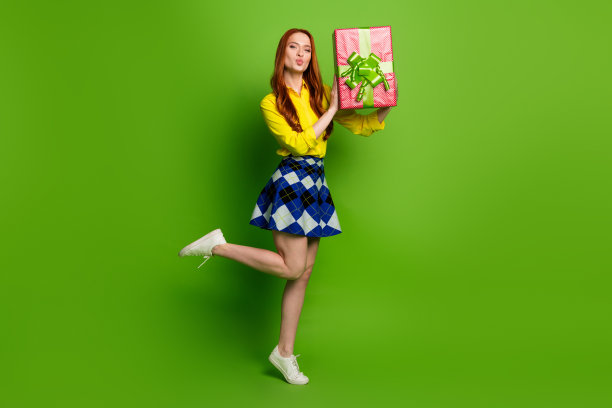 照片的华丽的积极高兴的女人穿着黄色时髦的衣服收到礼物孤立的绿色背景图片下载