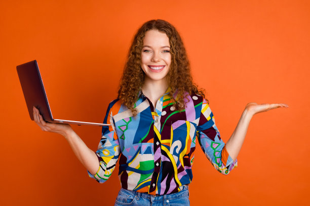 照片中可爱开朗的女孩穿着时尚的印花衣服，上面有新闻标志品牌的空白空间，孤立在橙色的背景上图片下载