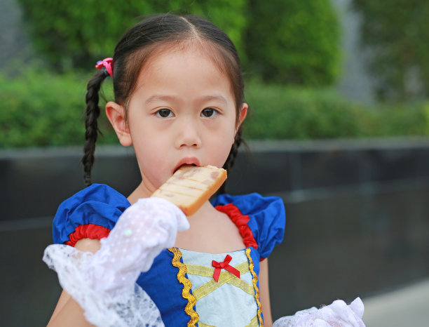 穿着奇幻服装的亚洲女孩正在吃烤火腿片。图片下载