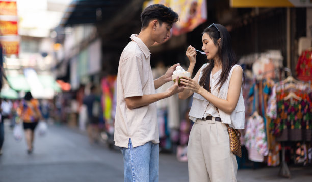 亚洲游客朋友走在街头的零售市场上，他们正在街边小吃上买美味的冰淇淋。图片下载
