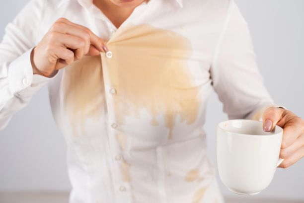 笨手笨脚的女商人把一杯黑咖啡洒在了衬衫上。图片下载