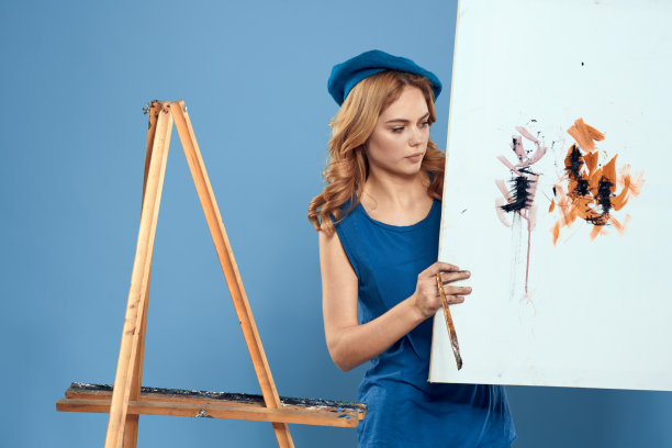 女艺术家尾手毛笔绘画艺术创意生活方式蓝色背景图片下载