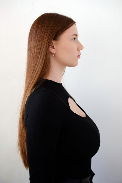 年轻女孩大码黑色t恤模特照片右看近距离的白色背景图片下载