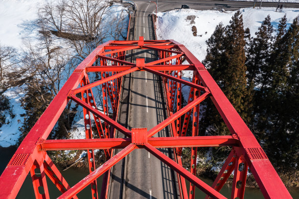 无人机照片:红色桁架桥和阳光明媚的冬季大自然图片下载