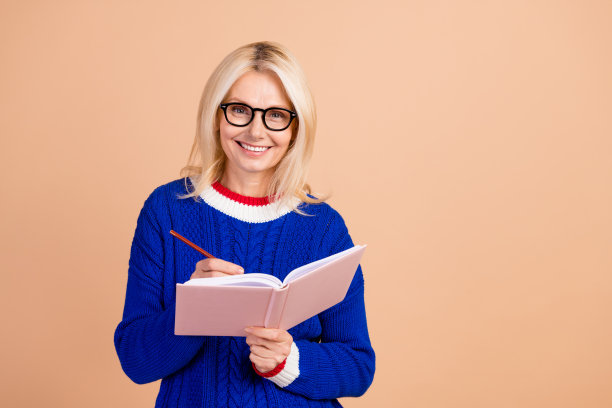 照片上的牙齿灿烂的好女人穿着针织品毛衣，戴着眼镜，在黄褐色的背景上写着要做的事情图片下载