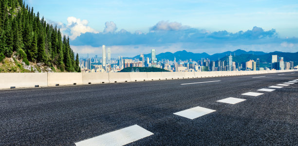 柏油高速公路与山道配以城市天际线美景图片下载