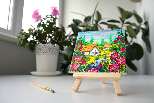 一个花瓶的背景上有一张乌克兰村庄的照片，上面有一个木制画架。装饰艺术。彼得里基夫卡画静物画。图片下载