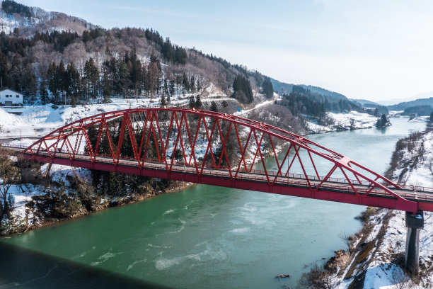 无人机照片:红色桁架桥和阳光明媚的冬季大自然图片下载