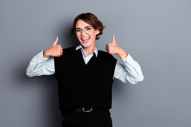 照片令人惊叹的积极的女士穿着黑色时尚的衣服两个大拇指酷提供房地产机构孤立的灰色背景图片下载