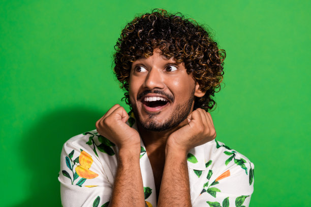 照片肖像漂亮的年轻男性看空空间欣赏穿着时尚的柑橘印花服装孤立的绿色背景图片下载