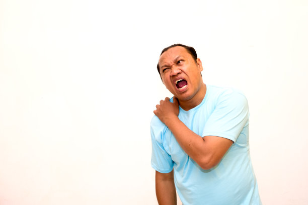 一名男子感到肩膀疼痛，孤立的摄影棚拍摄。孤立的白色背景图片下载