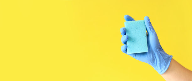 男人的手戴着带海绵的乳胶手套图片下载