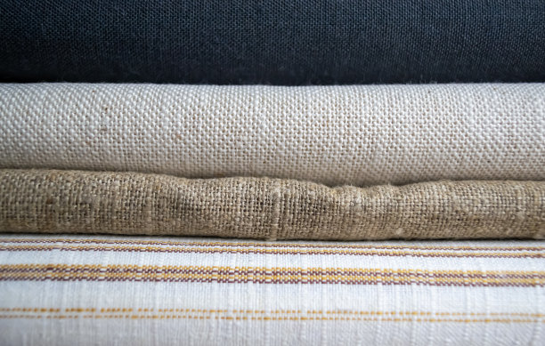 家用纺织品。不同的织物叠在一起。这些织物被折叠起来了。纺织品的种类。图片下载