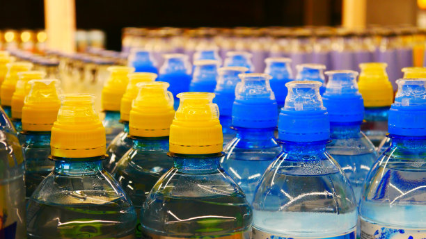 杂货店仓库里有许多黄色和蓝色的塑料瓶装水图片下载
