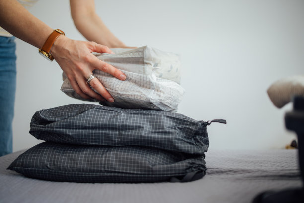 女人的手把袋子放在床上的特写照片图片下载