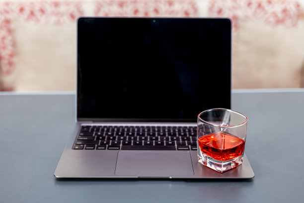 桌上有红酒和笔记本电脑图片下载